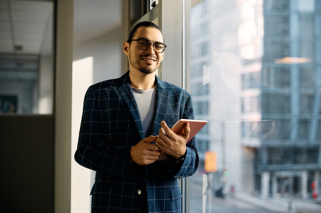 Portrait of Latin American businessman with touchpad in the office looking at camera.